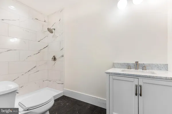 a bathroom with a granite countertop toilet sink and mirror