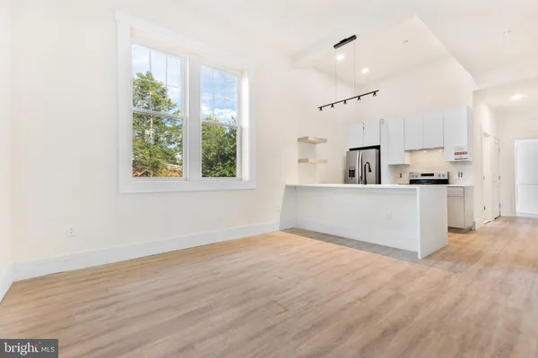 a view of a kitchen with wooden floor and windows