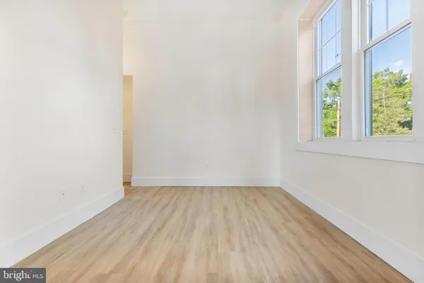 a view of a room that has wooden floor and window
