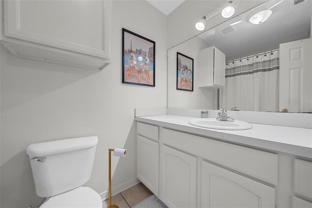 1915 South 7th Street Waco, TX 76706 - Photo 22 of 40 a bathroom with a toilet a sink and mirror