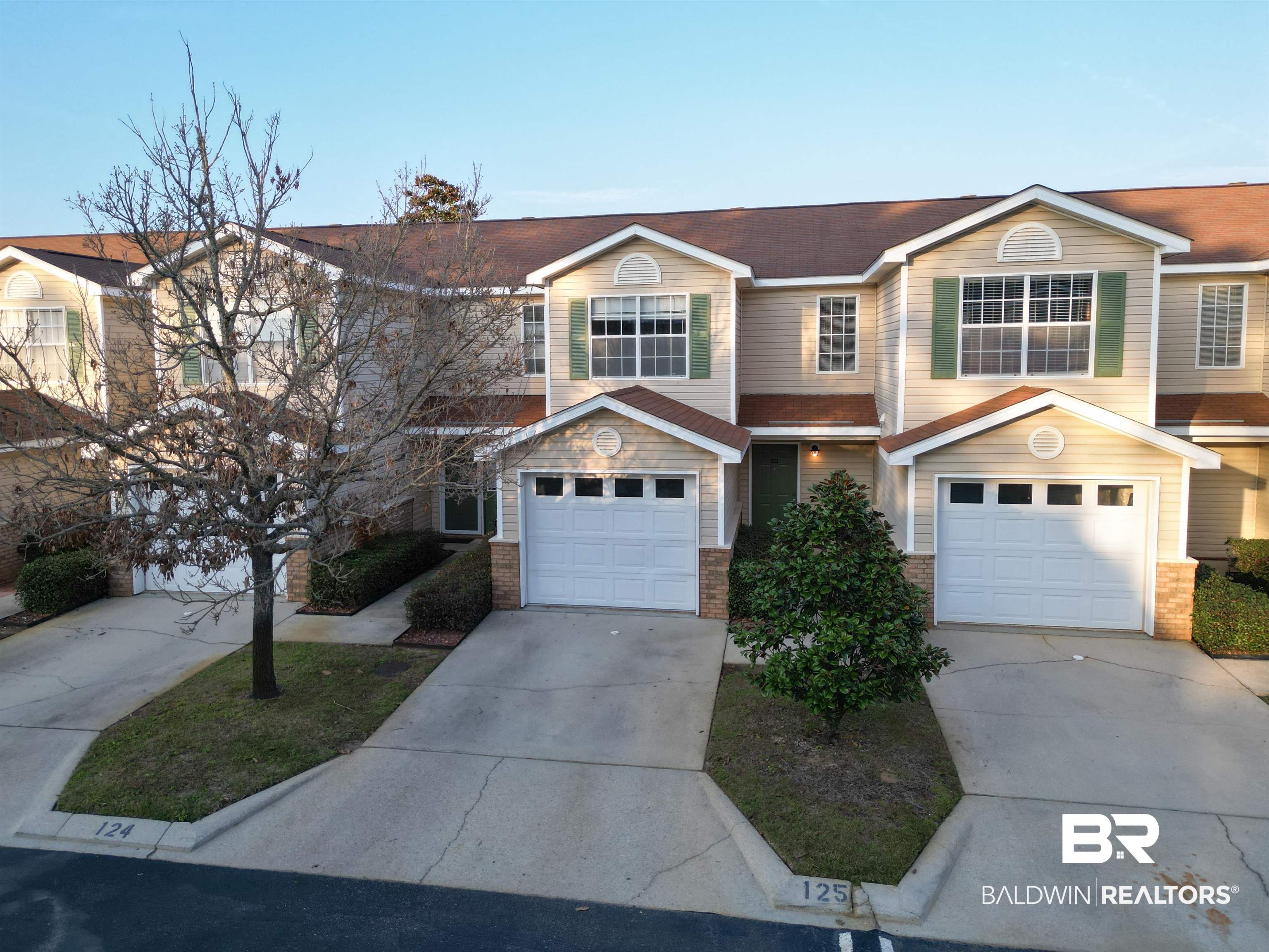 1517 Regency Road, Unit 125 Gulf Shores, AL 36542 - Photo 1 of 26 Traditional-style house with concrete driveway, a garage, and brick siding