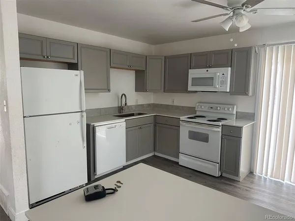 a kitchen with white cabinets and white appliances