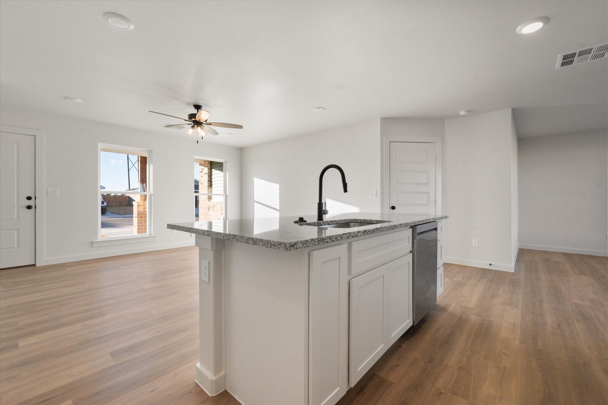6311 Volney Avenue Lubbock, TX 79407 - Photo 11 of 23 a kitchen with a sink cabinets and wooden floor