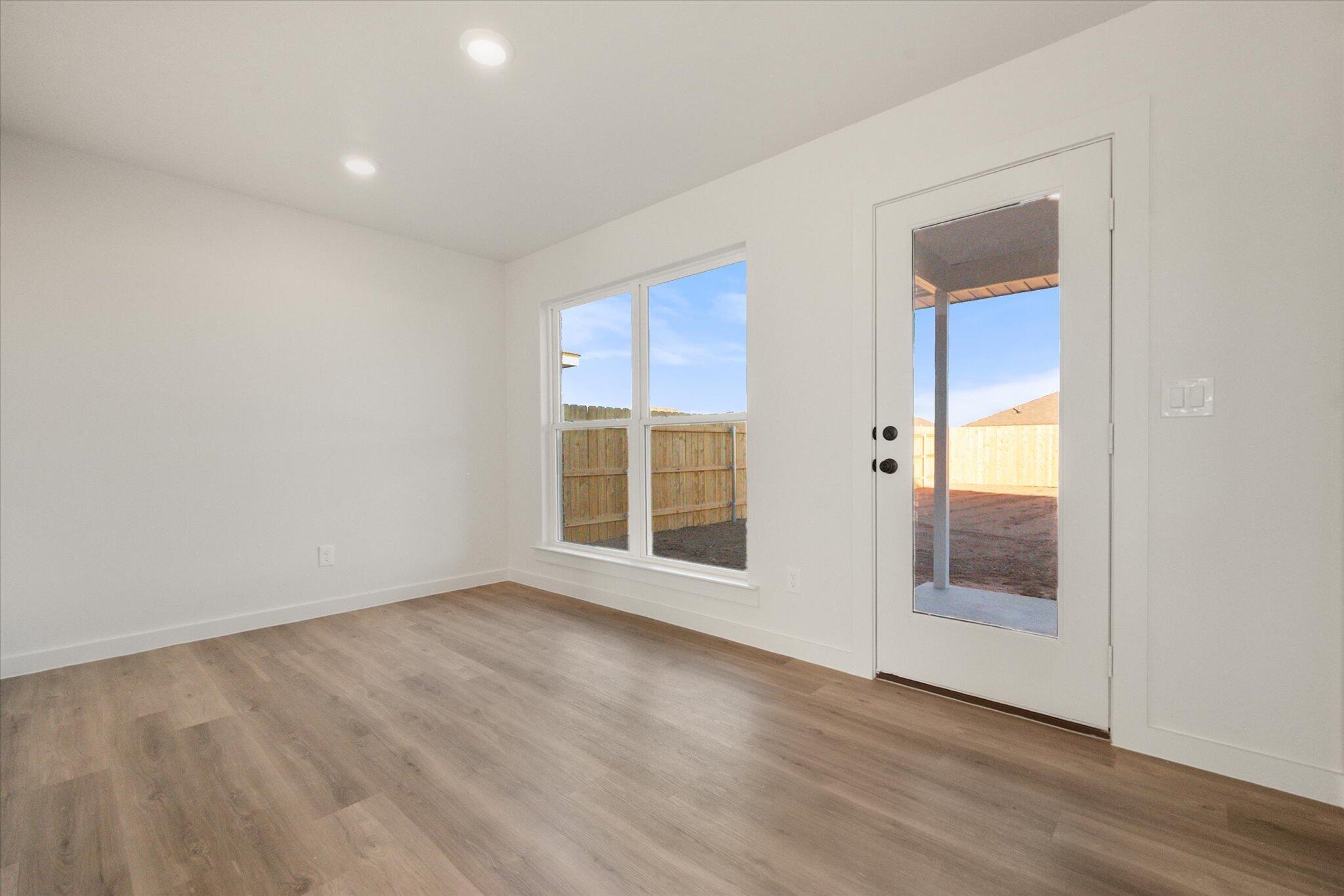 6311 Volney Avenue Lubbock, TX 79407 - Photo 12 of 23 an empty room with wooden floor and windows