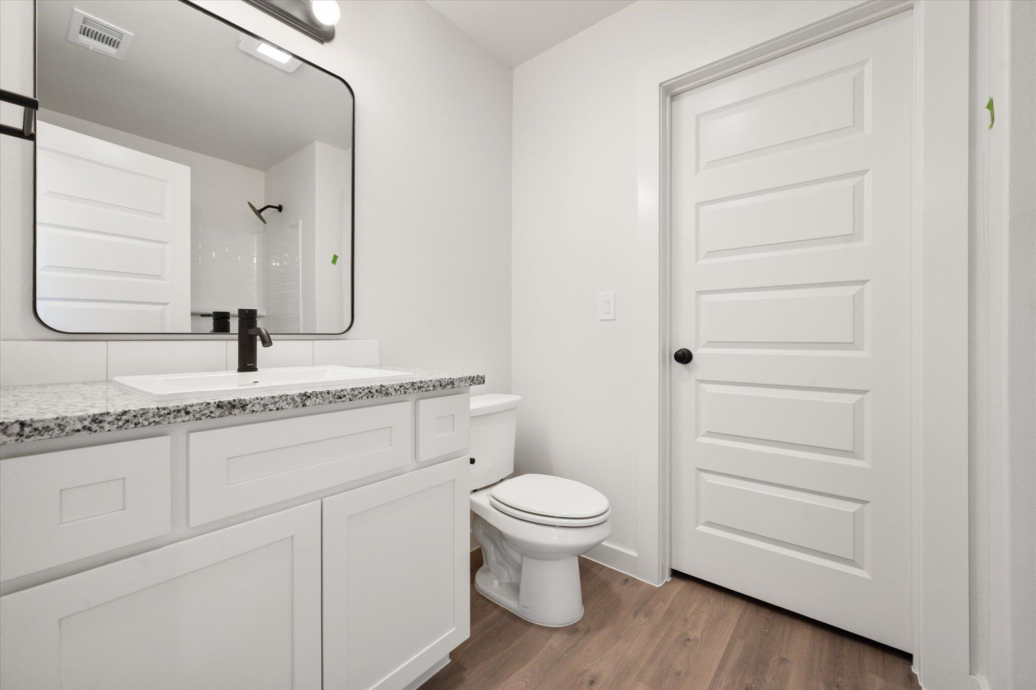 6311 Volney Avenue Lubbock, TX 79407 - Photo 15 of 23 a bathroom with a granite countertop toilet sink and mirror