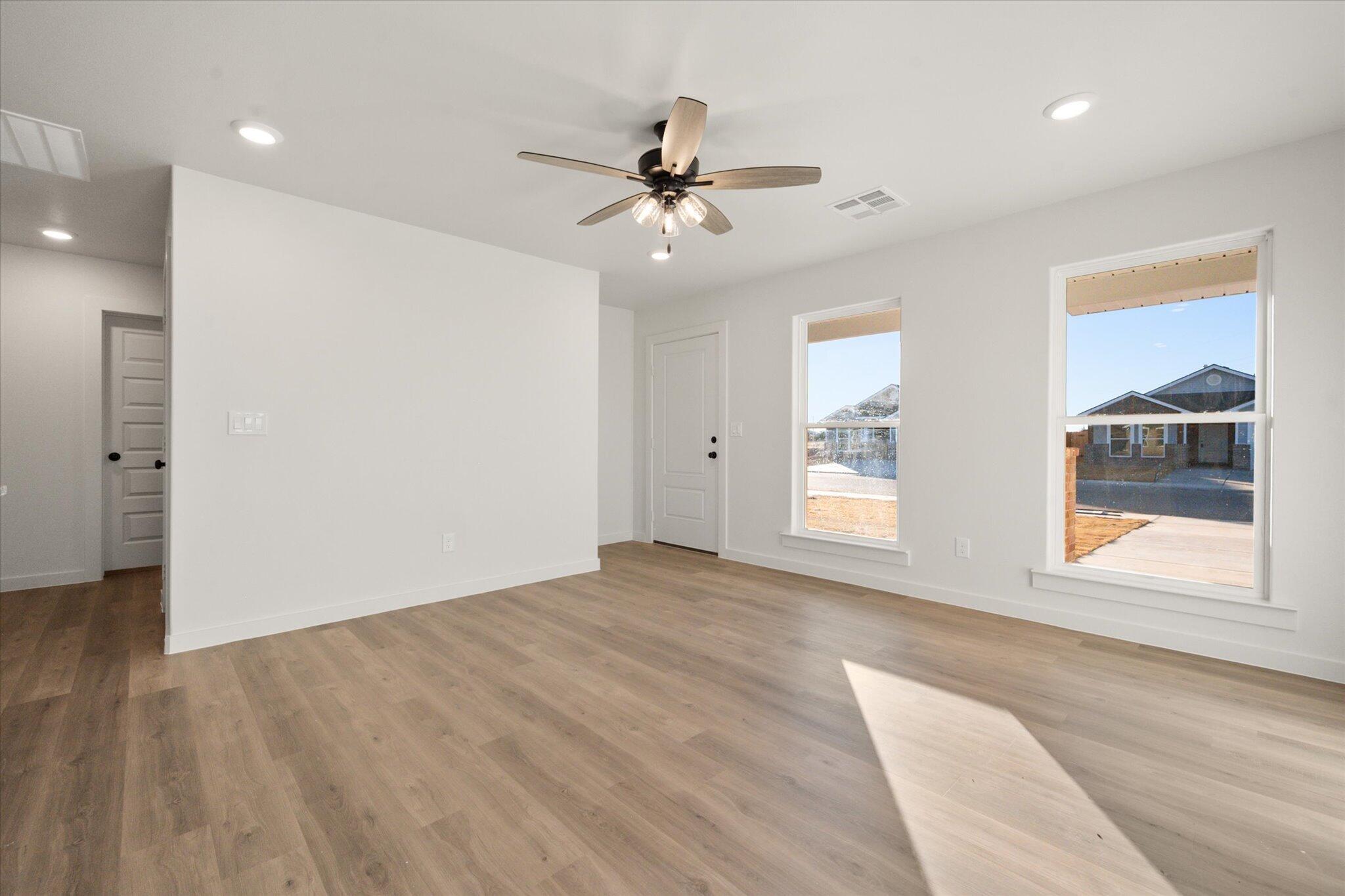 6311 Volney Avenue Lubbock, TX 79407 - Photo 5 of 23 a view of an empty room with a window and wooden floor