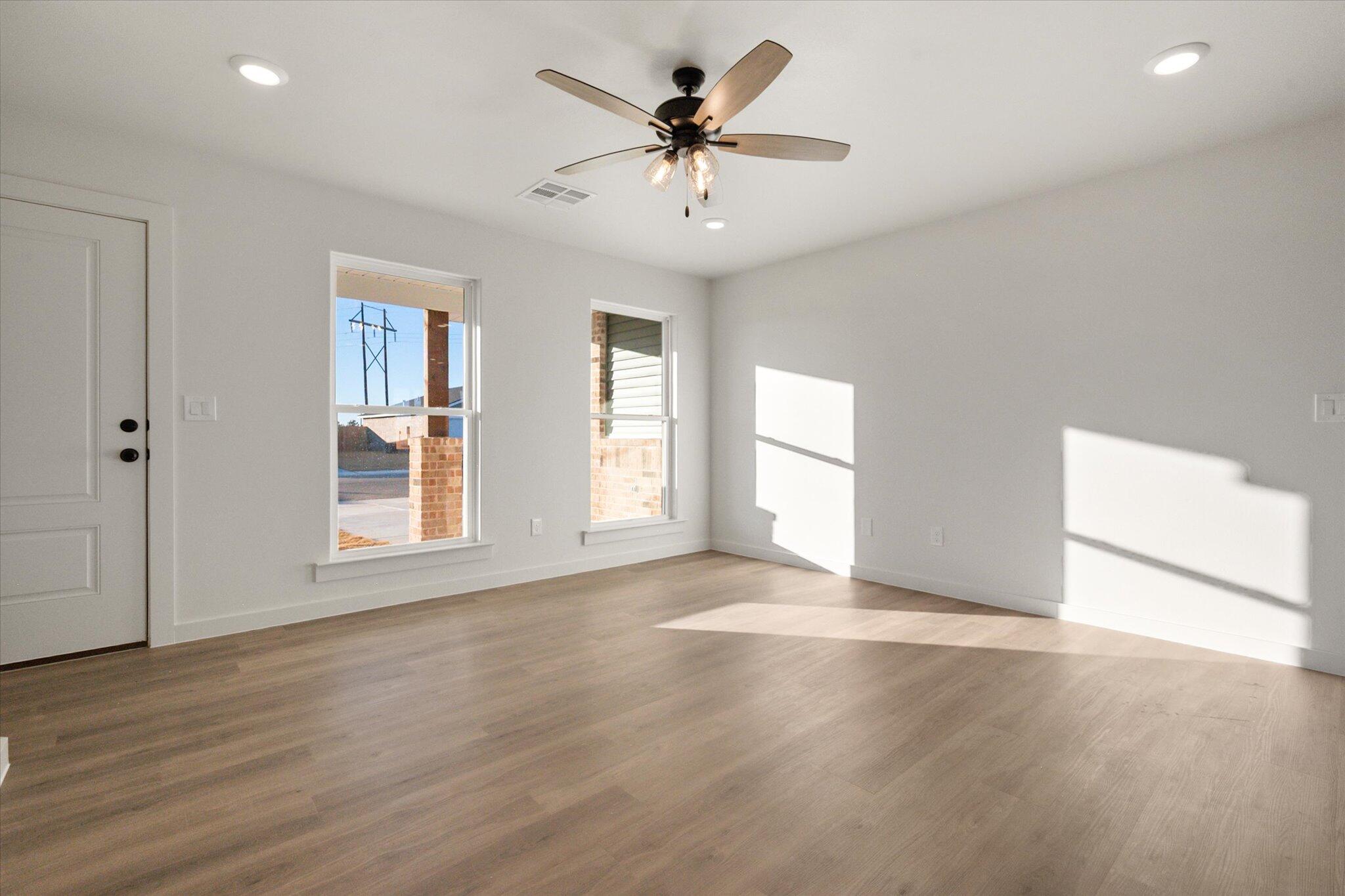 6311 Volney Avenue Lubbock, TX 79407 - Photo 6 of 23 an empty room with wooden floor and windows