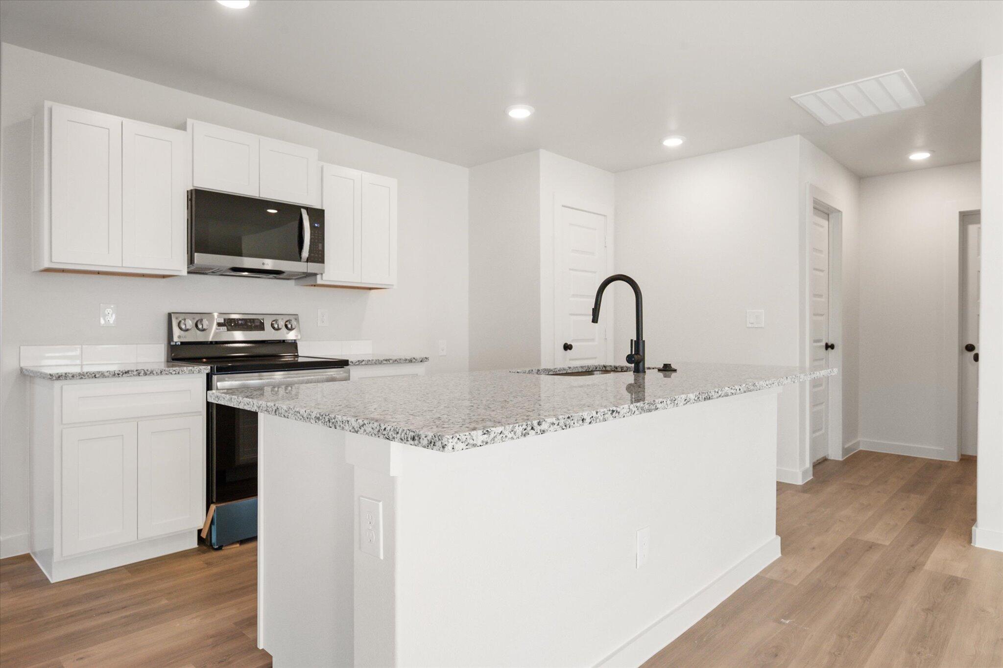 6311 Volney Avenue Lubbock, TX 79407 - Photo 9 of 23 a kitchen with a sink a microwave a refrigerator and cabinets