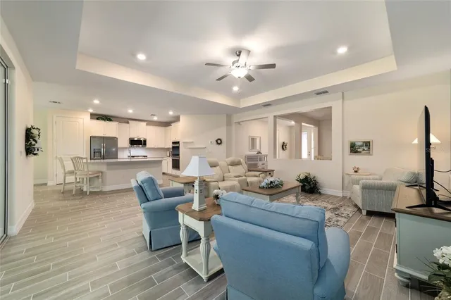 a living room with furniture and a view of kitchen