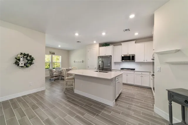 a kitchen with white cabinets and stainless steel appliances