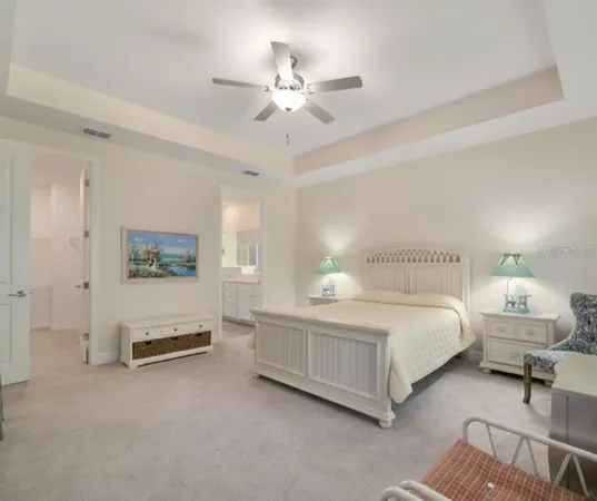 a spacious bedroom with a bed a couch and a chandelier
