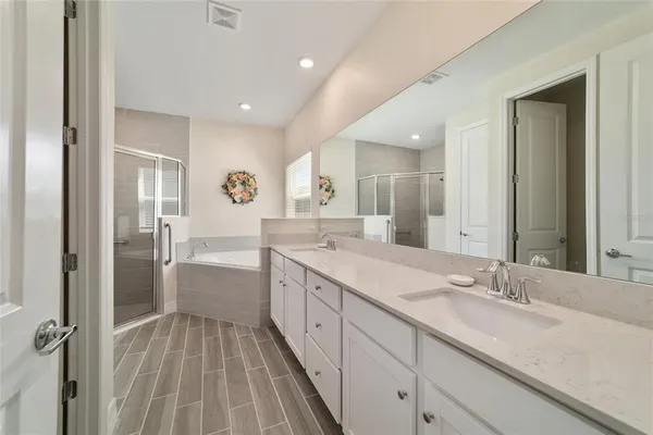 a spacious bathroom with a granite countertop sink mirror and a bathtub