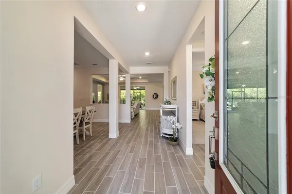 a view of a hallway with furniture and wooden floor