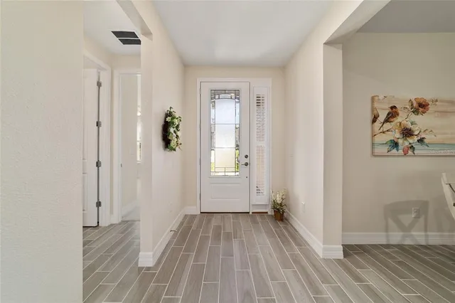 a view of a hallway with wooden floor and closet