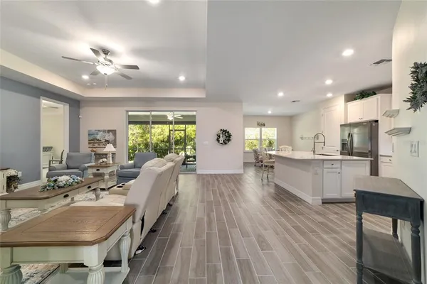 a living room with stainless steel appliances kitchen island granite countertop furniture wooden floor and a view of kitchen