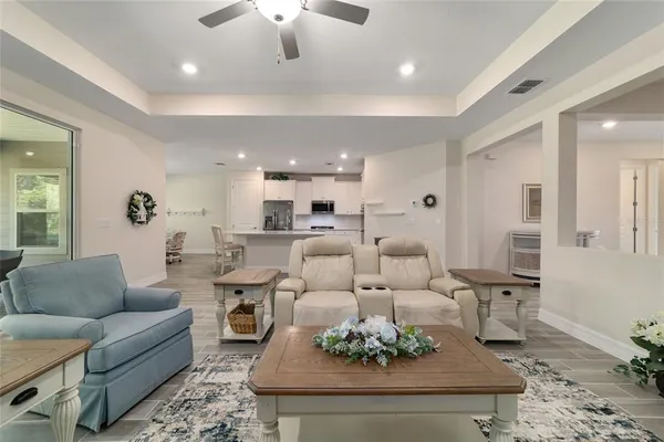 a living room with furniture potted plant and kitchen view