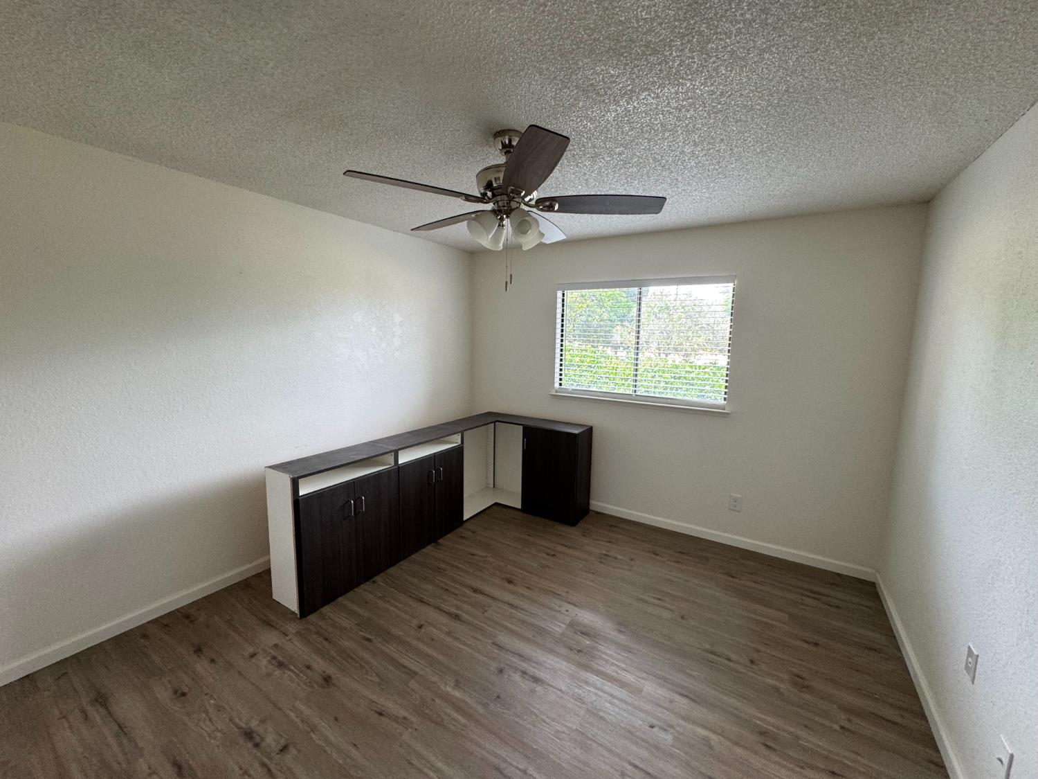 21293 East American Avenue Reedley, CA 93654 - Photo 7 of 19 an empty room with windows and fan
