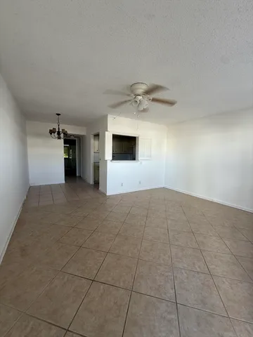 an empty room with a empty space and chandelier fan