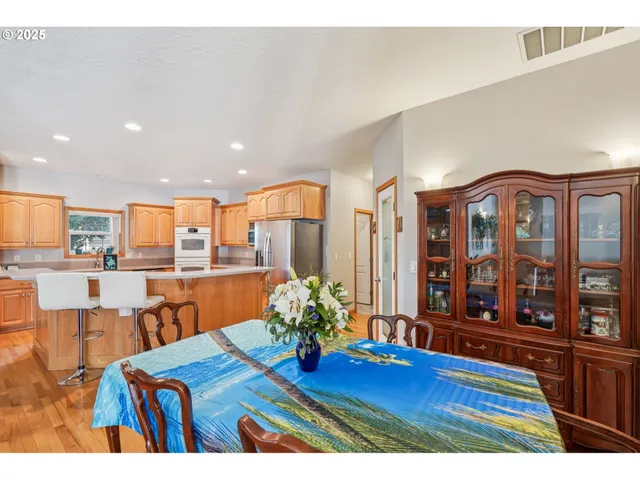 a living room with furniture dining table a rug and kitchen view