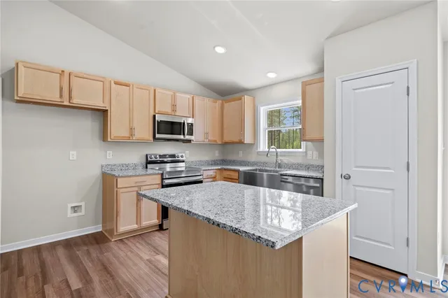 a kitchen with stainless steel appliances granite countertop a stove a sink and a microwave