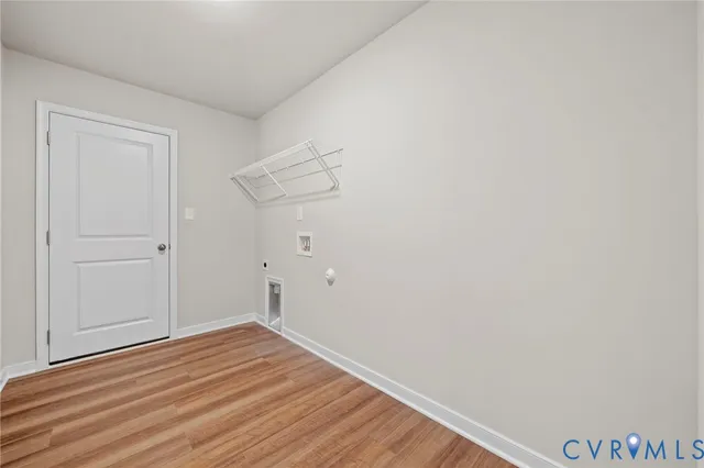 an empty room with a chandelier fan and windows