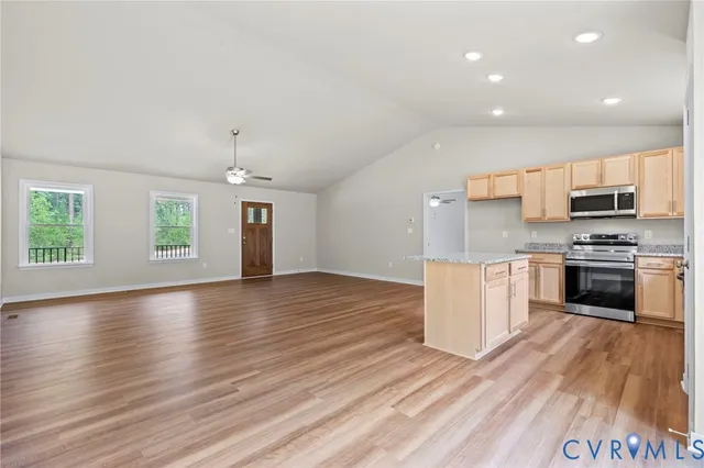 a view of a kitchen with wooden floor and a ceiling fan