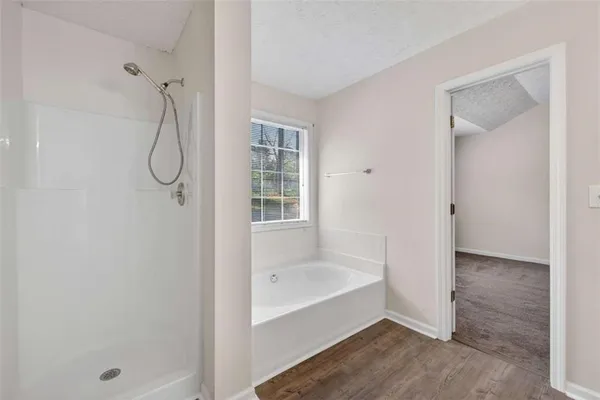 a view of a hallway with wooden floor and closet area