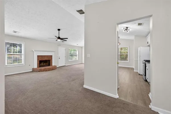 an empty room with windows and a ceiling fan