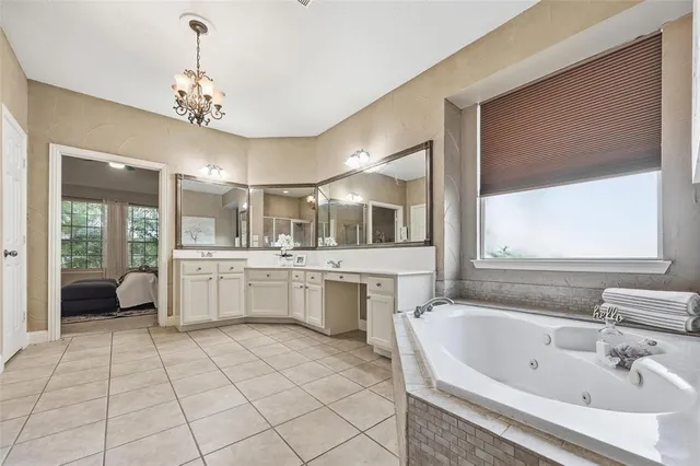 a large white bathroom with a large tub and sink