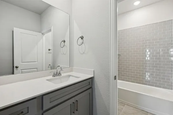 a bathroom with a sink double vanity granite tub shower and a mirror