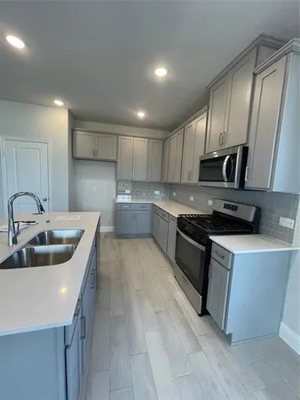 a kitchen with stainless steel appliances granite countertop a sink a stove and a refrigerator