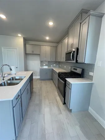 a large kitchen with stainless steel appliances granite countertop a sink stove and cabinets