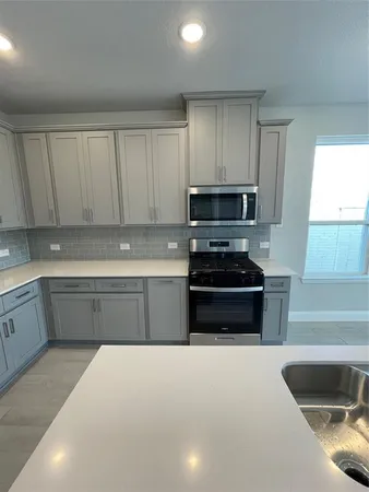 a kitchen with granite countertop a stove and a sink