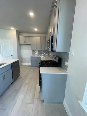 a view of living room with stainless steel appliances wooden floor and large window