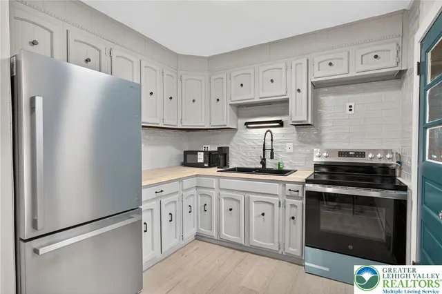 a kitchen with cabinets stainless steel appliances and a refrigerator