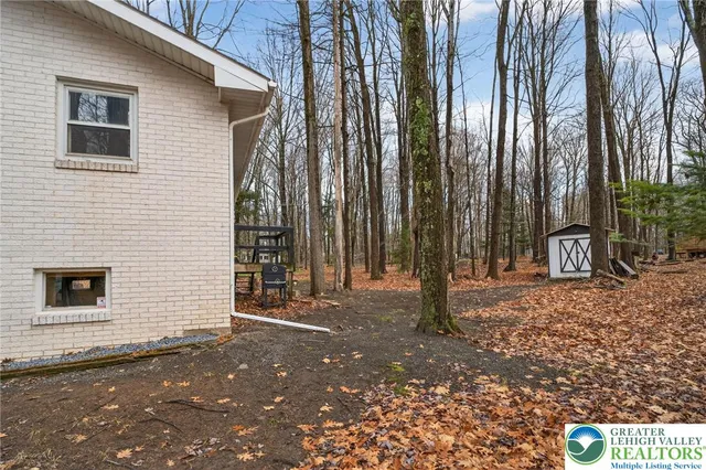 a view of a house with backyard and trees