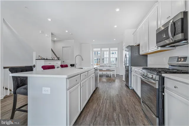 a kitchen that has a lot of cabinets and wooden floor