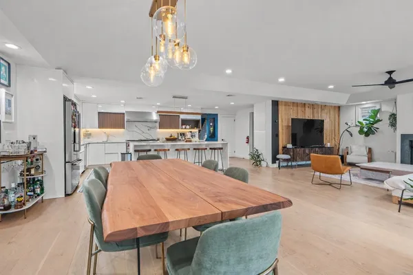 a large kitchen with sink a refrigerator and chairs
