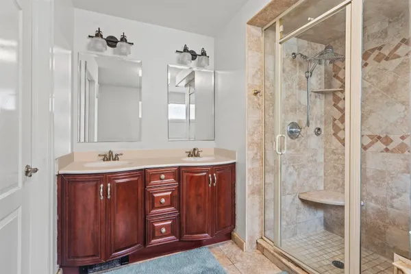 a bathroom with a double vanity sink mirror and shower