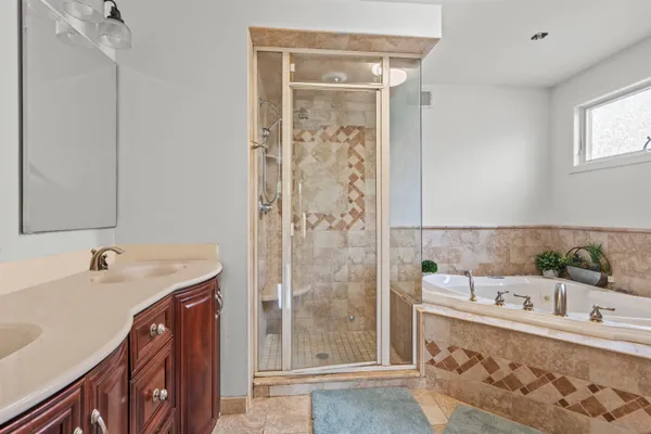 a bathroom with a tub sink and mirror