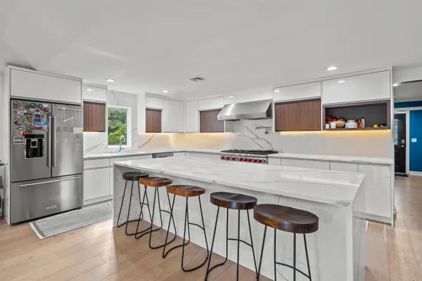 a kitchen with stainless steel appliances granite countertop a refrigerator a stove a sink and a refrigerator