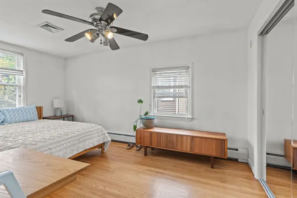 a bedroom with a bed a chandelier and a window
