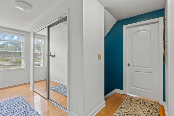 a view of a hallway to a livingroom with furniture and wooden floor