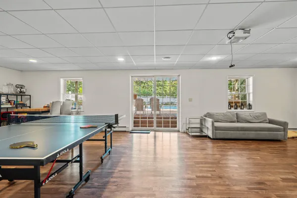 a living room with furniture a flat screen tv and wooden floor