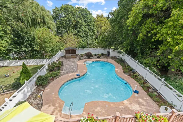 a view of a swimming pool with a yard and seating space