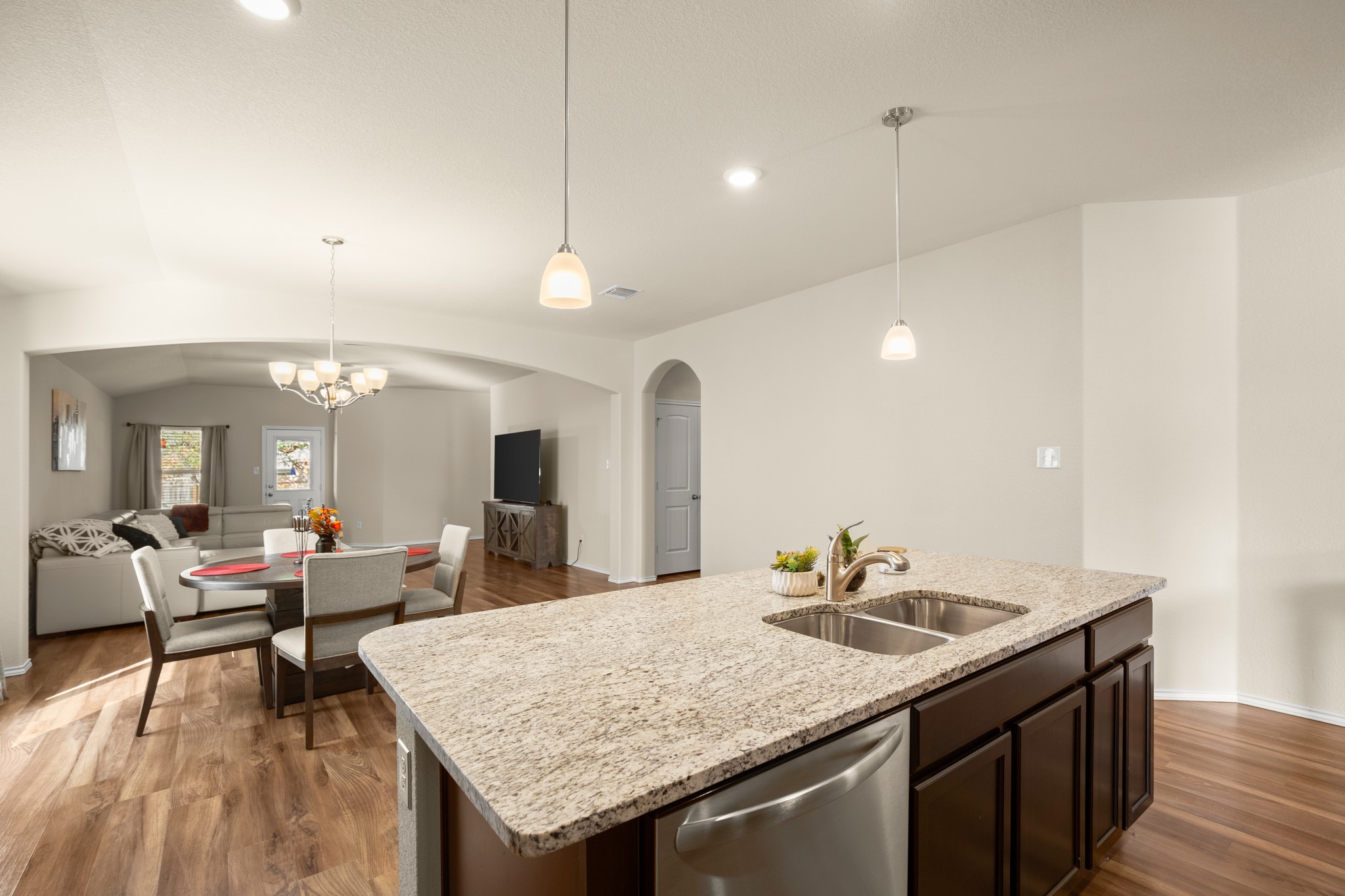 5526 Perdita Drive Belton, TX 76513 - Photo 25 of 26 Kitchen featuring open floor plan, arched walkways, stainless steel dishwasher, dark wood finish cabinets, and dark wood-type flooring