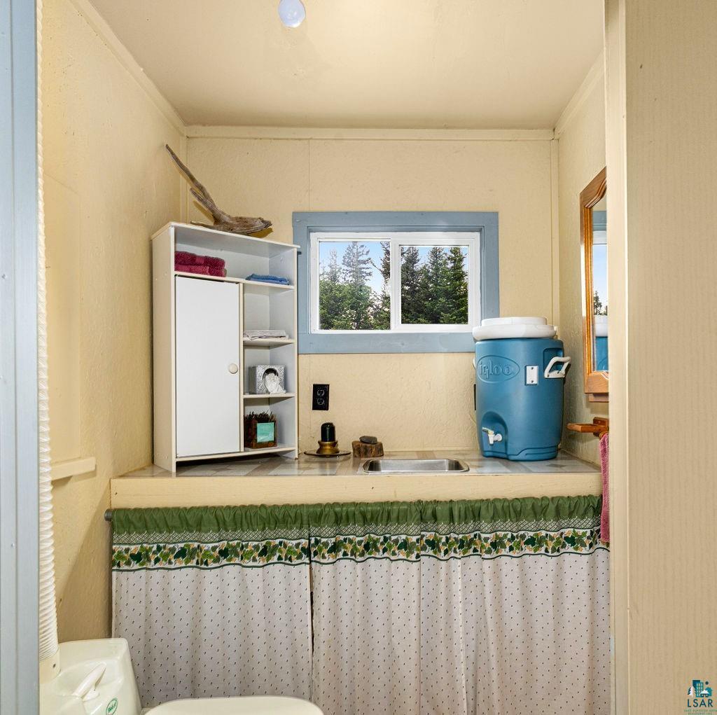 1268 Tom Lake Road Hovland, MN 55606 - Photo 22 of 56 Compact vanity area featuring a built-in sink, tiled countertop, and a window with natural light