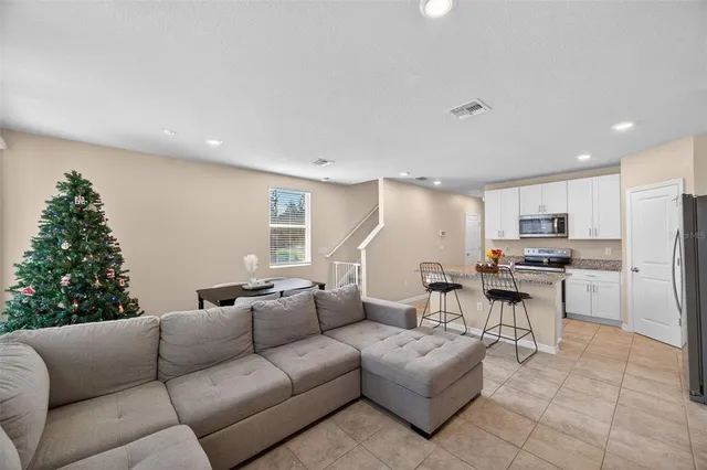 a living room with furniture kitchen view and a window