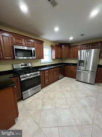a kitchen with stainless steel appliances granite countertop a stove refrigerator and microwave