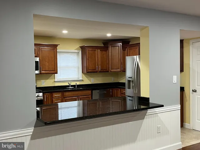 a kitchen with stainless steel appliances granite countertop a stove and a refrigerator